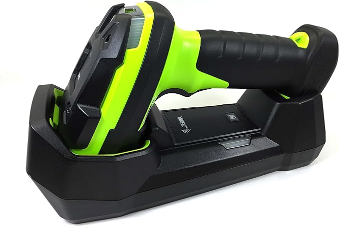 A handheld barcode scanner with a black body and green accents, equipped with a USB cable, sitting in a black cradle.
