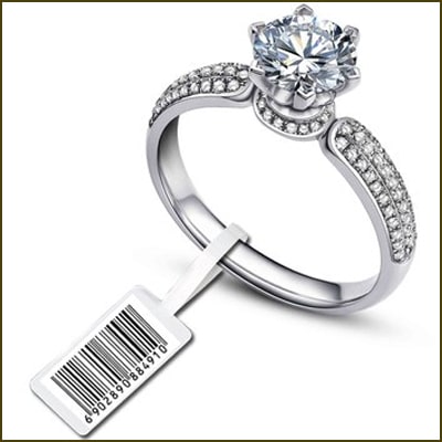 Silver ring with a large diamond and a bar code tag on a white background