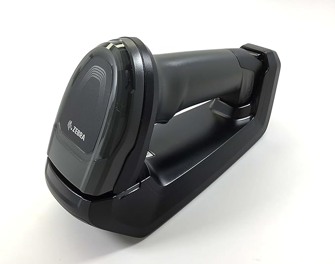 A black cordless handheld barcode scanner with a USB interface, placed on its charging dock.