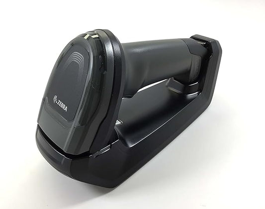 A black cordless handheld barcode scanner with a USB interface, placed on its charging dock.