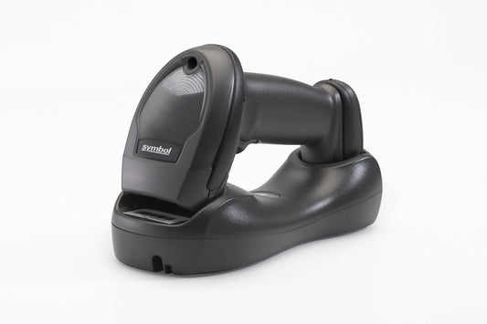 A black cordless linear imager barcode scanner with Bluetooth connectivity, resting on its charging cradle.