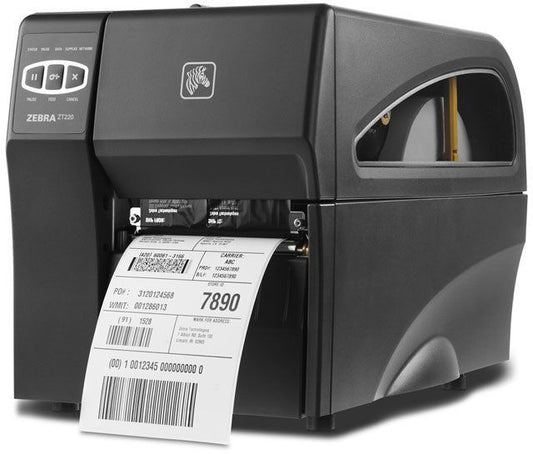A Zebra ZT220 barcode label printer in black, with a label printing out from the bottom slot.