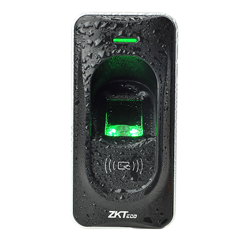 Zkteco FR1200 Fingerprint Reader, with a green light illuminated over the fingerprint sensor, mounted on a wall and exposed to rain.